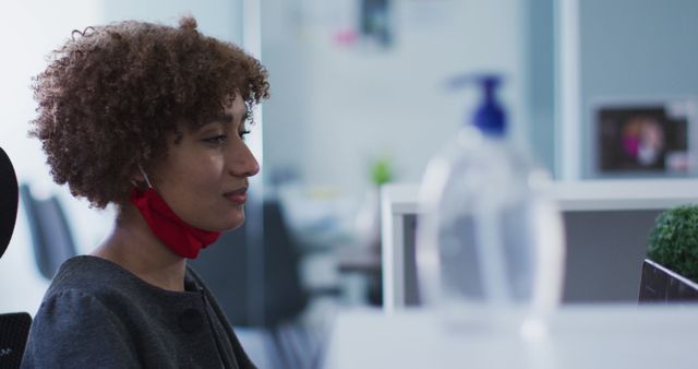 Woman Working at Office Desk with Red Face Mask Lowered - Download Free Stock Images Pikwizard.com