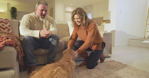 Happy couple bonding with golden retriever in cozy living room
