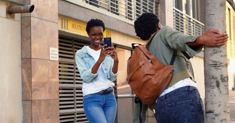 Women Enjoying Photography on Urban Sidewalk