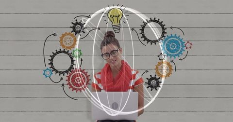 Young Woman Typing on Laptop with Innovation Graphs on Wall