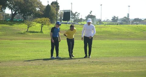 Men Exploring Grass Field on Sunny Day