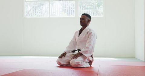 Teen Judoka Meditating in White Gi Before Judo Practice