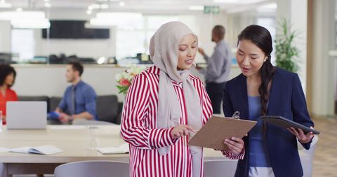 Diverse Business Professionals Discussing Work in Modern Office
