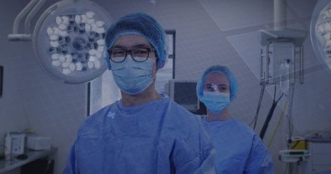 Surgical team preparing in operating room wearing sterile gowns, masks, caps and goggles
