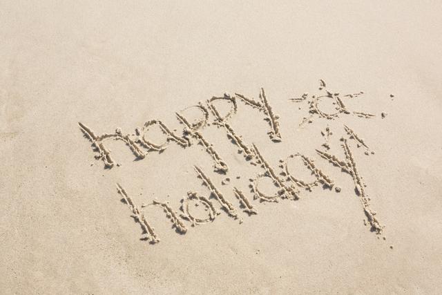 Handwritten 'happy holiday' message on sandy beach, perfect for promoting summer vacations, travel destinations, and holiday greetings. Ideal for use in travel brochures, social media posts, and greeting cards.