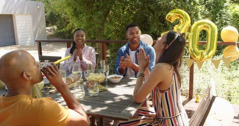 Friends Joyously Celebrating a Birthday Outdoors