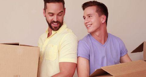 Young Men Enjoying Moving Day Unboxing Together - Download Free Stock Images Pikwizard.com
