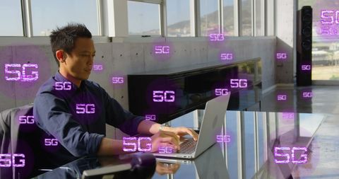 Businessman working on laptop in high-tech 5g enabled office