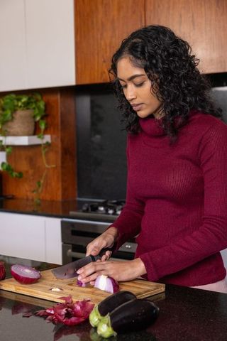 Woman Cooking with Fresh Vegetables in Home Kitchen
