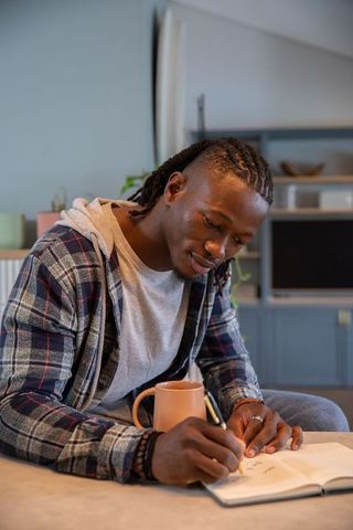 Man Writing Notes in Cozy Living Room