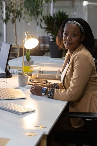 African american professional woman working at laptop in modern minimalist office space