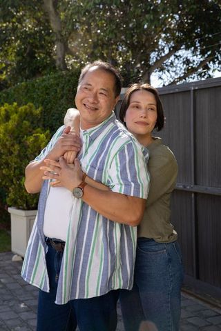 Happy Couple Embracing Outdoors on Sunny Day in Backyard Setting