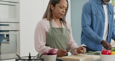 Senior couple preparing healthy meal together on kitchen island in modern home