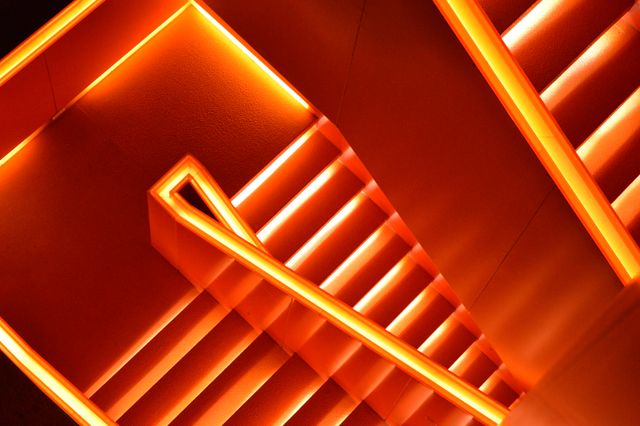 Abstract illuminated staircase showcasing modern architecture design and vibrant lighting. Ideal for use in articles or media emphasizing futuristic design, architectural minimalism, or modern interior decor. Useful for websites about creative construction, home improvement, and contemporary style ideas.