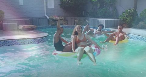 Friends Relaxing on Inflatables in Backyard Pool on Summer Day