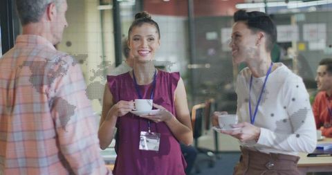 Business professionals communicating over coffee break in modern office