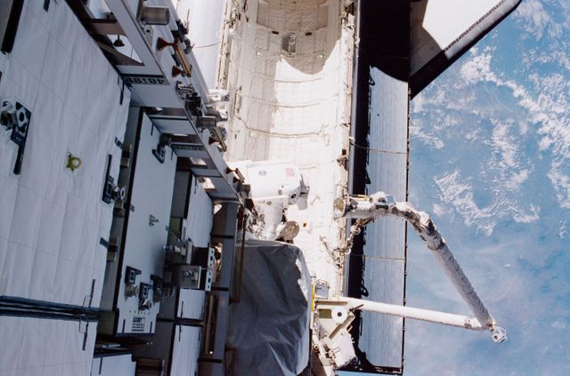 STS097-374-015 (5 December 2000) --- This high angle view shows astronaut Carlos I. Noriega, STS-97 mission specialist, traversing over Endeavour's cargo bay during the flight's first space walk on Dec. 5, 2000.  Astronaut Joseph R. Tanner, mission specialist,  was near the top of the P6 truss structure when he exposed the 35mm frame.  The Canadian-built Remote Manipulator System (RMS) arm, instrumental in the current operations, can be seen at bottom right.