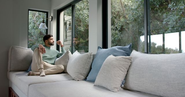 Man Relaxing on Couch by Large Window with Tree View - Download Free Stock Images Pikwizard.com