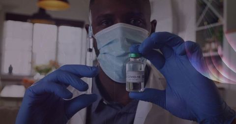 Medical professional preparing covid-19 vaccine in clinic with safety gear