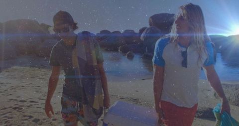 Casual beach walk with friends and cooler at sunset