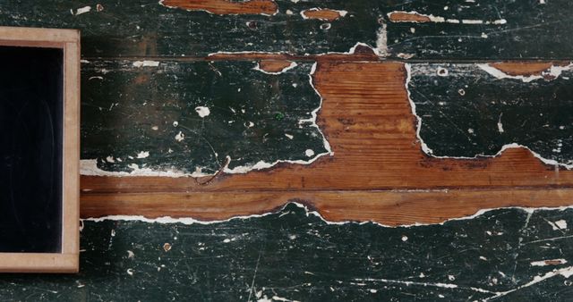 Featuring a distressed wooden surface with peeling paint and a partial chalkboard, this image exudes rustic charm and vintage character. Ideal for design projects needing backgrounds, textures, or concepts of age and history.