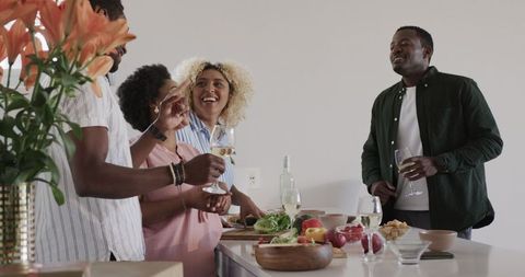 Friends Joyfully Cooking and Bonding in Modern Kitchen