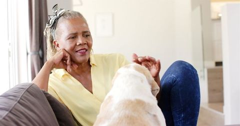 Senior Woman Relaxing at Home with Loyal Dog by Her Side