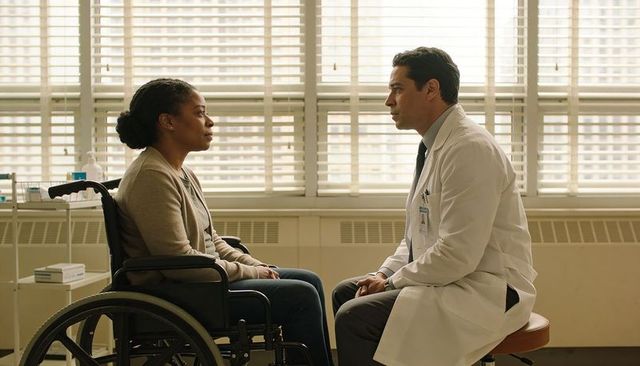 Doctor consulting wheelchair patient in clinic, listening and providing compassionate care