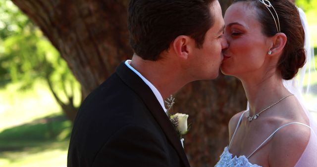 Newlywed couple sharing kiss outdoors at wedding - Download Free Stock Photos Pikwizard.com