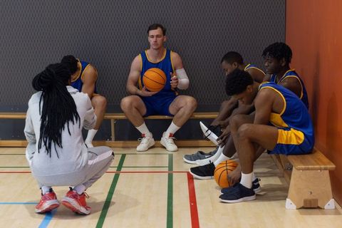 Diverse Basketball Team and Coach Motivational Strategy Meeting