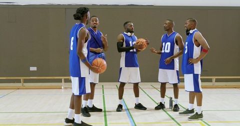 African american basketball team planning strategy and practicing together on indoor court