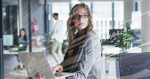 Businesswoman Analyzing Data With Laptop in Futuristic Office Environment