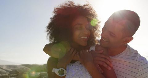 Biracial Couple Embracing on Sunny Beach
