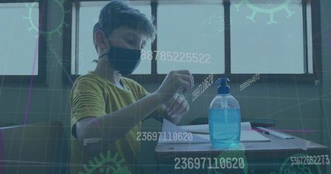 Schoolboy using hand sanitizer with covid-19 concept overlay