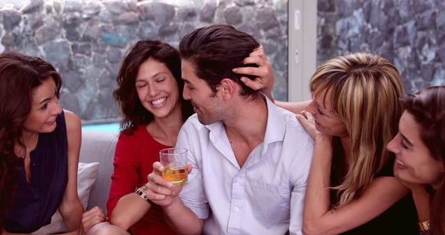 Group of friends laughing and enjoying drinks inside. Great for depicting cheerful moments, friendship, social gatherings, relaxation, and indoor entertainment.