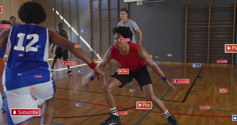 Defending guard crouching on court during indoor basketball game with social media overlays