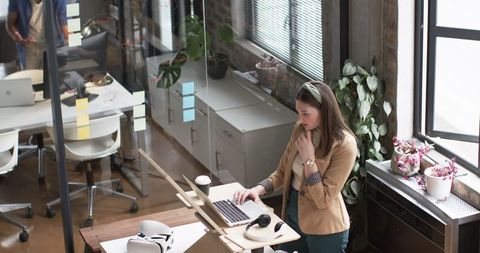 Focused Young Professional Woman Working on Computer in Modern Office Space