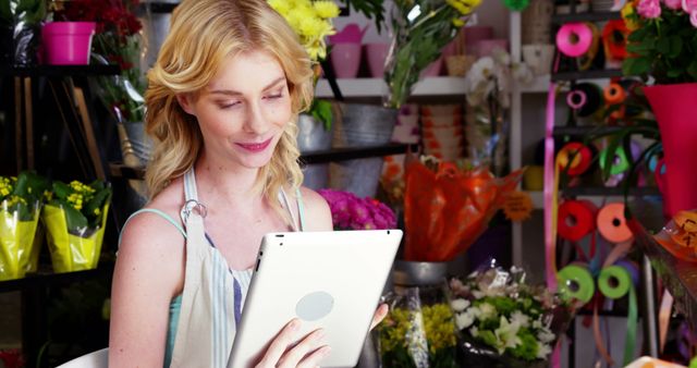 Smiling Florist Woman Using Tablet in Flower Shop - Download Free Stock Images Pikwizard.com