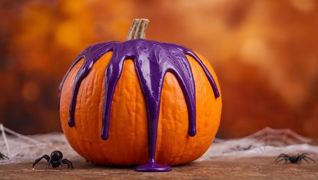 Orange Pumpkin Dripping Purple Paint With Wooden Table