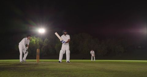 Indian batsman standing at crease under floodlights preparing to face ball in night cricket