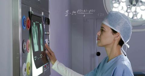 Surgeon Reviewing Chest X-Ray on Lightbox While Adjusting Controls in Operating Suite