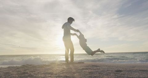 Father and Son Playing on Beach at Sunset Creating Unforgettable Moments