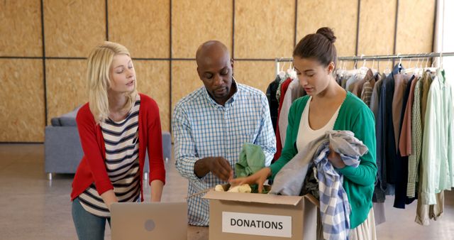 Diverse Team Sorting Clothing Donations at Charity Center - Download Free Stock Images Pikwizard.com