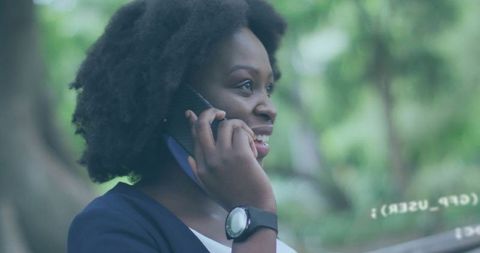 Smiling Woman Talking on Smartphone in Lush Garden Outdoors