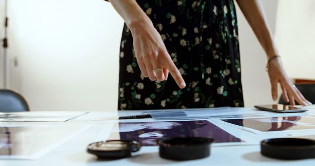 Photographer selecting prints on table in studio - Download Free Stock Images Pikwizard.com