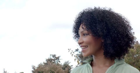 Smiling Woman Enjoying Nature with Trees and Clear Sky