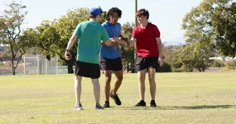 Teen friends tossing ball in sunny park celebrating teamwork and active outdoor lifestyle