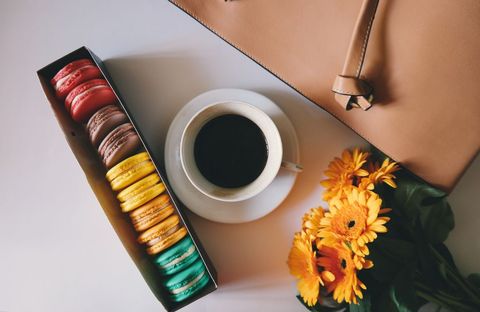 Colorful Macarons and Coffee with Marigolds on Desk