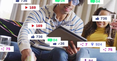Couple watching tablet and celebrating with champagne while social notifications pop up