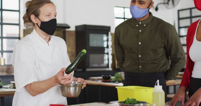 Chef Demonstrating Cooking Techniques to Class with Face Masks - Download Free Stock Images Pikwizard.com